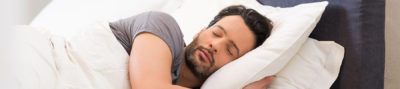 man sleeping in his bed