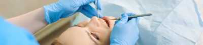 woman having her teeth examined by a dentist