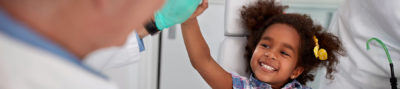 young dental patient giving her dentist a high five